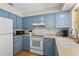 Well-lit kitchen featuring blue cabinets, matching appliances, and ample counter space at 409 Archibald Ave, Sarasota, FL 34243