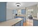Open kitchen showcasing blue cabinets, a breakfast bar, and sliding doors to the patio at 409 Archibald Ave, Sarasota, FL 34243