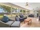 Relaxing sun room with large windows offering views of the backyard, ceiling fan, and tile flooring at 409 Archibald Ave, Sarasota, FL 34243