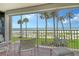 Cozy balcony featuring seating and views of the beach, ocean, and palm trees in a picturesque setting at 4325 Gulf Of Mexico Dr # 204, Longboat Key, FL 34228