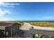 Elevated beach access with wooden stairs leading down to the sandy beach and clear blue ocean at 4325 Gulf Of Mexico Dr # 204, Longboat Key, FL 34228