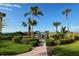 Beautifully landscaped beach access with tropical palms and brick path leading to the ocean at 4325 Gulf Of Mexico Dr # 204, Longboat Key, FL 34228