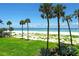 Serene view of the beach with tropical palm trees along the shore and the ocean stretching to the horizon at 4325 Gulf Of Mexico Dr # 204, Longboat Key, FL 34228