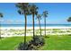 Scenic view of the sandy beach, calm ocean, and palm trees, showcasing the property's ideal location at 4325 Gulf Of Mexico Dr # 204, Longboat Key, FL 34228