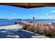 Scenic waterfront view from a picnic table under a shelter, showcasing a dock extending into the clear blue water at 4325 Gulf Of Mexico Dr # 204, Longboat Key, FL 34228
