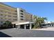 Exterior view of the building featuring a covered parking area and manicured landscaping at 4325 Gulf Of Mexico Dr # 204, Longboat Key, FL 34228