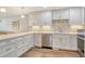 Bright kitchen features stone counters, tile backsplash, white cabinets, and stainless steel appliances at 4325 Gulf Of Mexico Dr # 204, Longboat Key, FL 34228