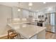 Bright kitchen features stone counters, tile backsplash, white cabinets, and stainless steel appliances at 4325 Gulf Of Mexico Dr # 204, Longboat Key, FL 34228