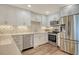 Bright kitchen features stainless steel appliances, tile backsplash, and white cabinets at 4325 Gulf Of Mexico Dr # 204, Longboat Key, FL 34228