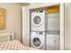 Stackable washer and dryer inside closet with granite counter and cabinet for tidy convenience at 4325 Gulf Of Mexico Dr # 204, Longboat Key, FL 34228