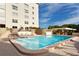 Inviting outdoor pool area with lounge chairs, brick patio, and tropical landscaping at 4325 Gulf Of Mexico Dr # 204, Longboat Key, FL 34228