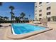 Sparkling outdoor pool with a spacious patio, lounge chairs, and views of the adjacent building at 4325 Gulf Of Mexico Dr # 204, Longboat Key, FL 34228