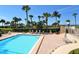Relax by the community pool with clear blue water and lush landscaping with palm trees near the ocean at 4325 Gulf Of Mexico Dr # 204, Longboat Key, FL 34228