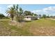 Backyard featuring lush grass and mature landscaping, providing a private outdoor space at 4330 Alligator Dr, Venice, FL 34293