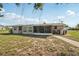 Backyard view of the home with a screened lanai, exterior storage, and partial grass coverage at 4330 Alligator Dr, Venice, FL 34293