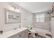 Updated bathroom features tile surround shower, gray vanity with sink, and decorative shelves at 4330 Alligator Dr, Venice, FL 34293