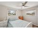 Cozy bedroom featuring a ceiling fan, two windows, and a full-sized bed with blue comforter at 4330 Alligator Dr, Venice, FL 34293