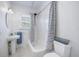Clean bathroom with a pedestal sink, tiled floors, and a tub-shower combo featuring a striped shower curtain at 520 27Th W St, Bradenton, FL 34205