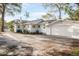 Rear exterior of a two-story white home with a detached garage and an asphalt driveway at 520 27Th W St, Bradenton, FL 34205