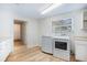 Bright laundry room with modern washer and dryer, white cabinets, and hardwood floors at 520 27Th W St, Bradenton, FL 34205