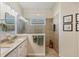 Bright bathroom featuring a tiled walk-in shower and double vanity with a stone countertop at 5333 Tide Point Way, Bradenton, FL 34208