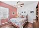 Nautical themed bedroom with a wooden ceiling fan, and white and coral bedding at 5333 Tide Point Way, Bradenton, FL 34208