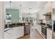 Bright kitchen features white cabinetry, stainless steel appliances, and black granite countertops at 5333 Tide Point Way, Bradenton, FL 34208