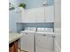 Clean laundry room with washer, dryer, white cabinets, and pale blue walls at 5333 Tide Point Way, Bradenton, FL 34208
