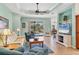 Cozy living room with comfortable seating, tile floors, ceiling fan, and sliding glass doors to the outdoor area at 5333 Tide Point Way, Bradenton, FL 34208