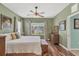 Comfortable bedroom featuring hardwood floors, ceiling fan, and views of the backyard at 5333 Tide Point Way, Bradenton, FL 34208