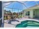 Outdoor dining and entertainment with a screened-in pool, outdoor seating, and manicured landscaping at 5333 Tide Point Way, Bradenton, FL 34208