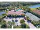 Aerial view of community pool, clubhouse, tennis courts, parking, and tropical landscaping at 5863 Cavano Dr, Sarasota, FL 34231