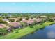 Aerial view of homes with screened lanais and scenic pond views, showcasing community layout at 5863 Cavano Dr, Sarasota, FL 34231