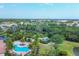 A lush aerial view of the community pool, pickleball courts, and surrounding landscape at 5863 Cavano Dr, Sarasota, FL 34231