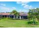 A beautiful backyard with a screened-in lanai, lush landscaping, and mature trees at 5863 Cavano Dr, Sarasota, FL 34231