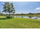 A peaceful backyard with a well-maintained lawn and a scenic view of the pond at 5863 Cavano Dr, Sarasota, FL 34231