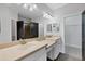Bright bathroom featuring double sinks, a large mirror, and sleek finishes with convenient access to walk in closet at 5863 Cavano Dr, Sarasota, FL 34231