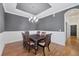 Dining room with dark wood table set, chandelier and gray accent wall and wood floors at 5863 Cavano Dr, Sarasota, FL 34231