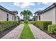 Paver driveway leading to a well-maintained home with lush landscaping on either side at 5863 Cavano Dr, Sarasota, FL 34231