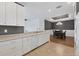 Open kitchen with white cabinets and stainless appliances next to dining area with dark wood table at 5863 Cavano Dr, Sarasota, FL 34231