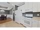 Bright kitchen with white appliances, tile floors, and breakfast bar next to the dining area at 5863 Cavano Dr, Sarasota, FL 34231