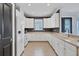 Bright kitchen with white cabinets, tile floors, gray accent wall, and stainless appliances at 5863 Cavano Dr, Sarasota, FL 34231