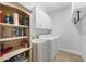 Bright laundry room with washer, dryer, utility sink, tile flooring, and ample storage cabinets at 5863 Cavano Dr, Sarasota, FL 34231