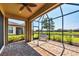 Screened patio area with brick flooring and a relaxing seating area overlooking the lake at 5863 Cavano Dr, Sarasota, FL 34231