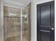 Modern tiled shower with glass door and built-in seat, complemented by a stylish accent and a matte-black door at 5863 Cavano Dr, Sarasota, FL 34231