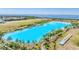 Large, pristine blue lagoon surrounded by lush landscapes and palm trees with waterfront living at 6028 Red Mangrove Ln, Bradenton, FL 34210