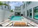 A modern backyard with a pool, an outdoor seating area and white walls at 6028 Red Mangrove Ln, Bradenton, FL 34210