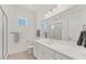 A bright bathroom with a large mirror, glass enclosed shower and neutral color scheme at 6028 Red Mangrove Ln, Bradenton, FL 34210