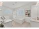 Bright bathroom featuring a soaking tub, dual vanities, and a glass-enclosed shower at 6028 Red Mangrove Ln, Bradenton, FL 34210