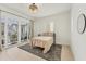 Bedroom with a woven ceiling fan, minimalist decor, and patio access at 6028 Red Mangrove Ln, Bradenton, FL 34210